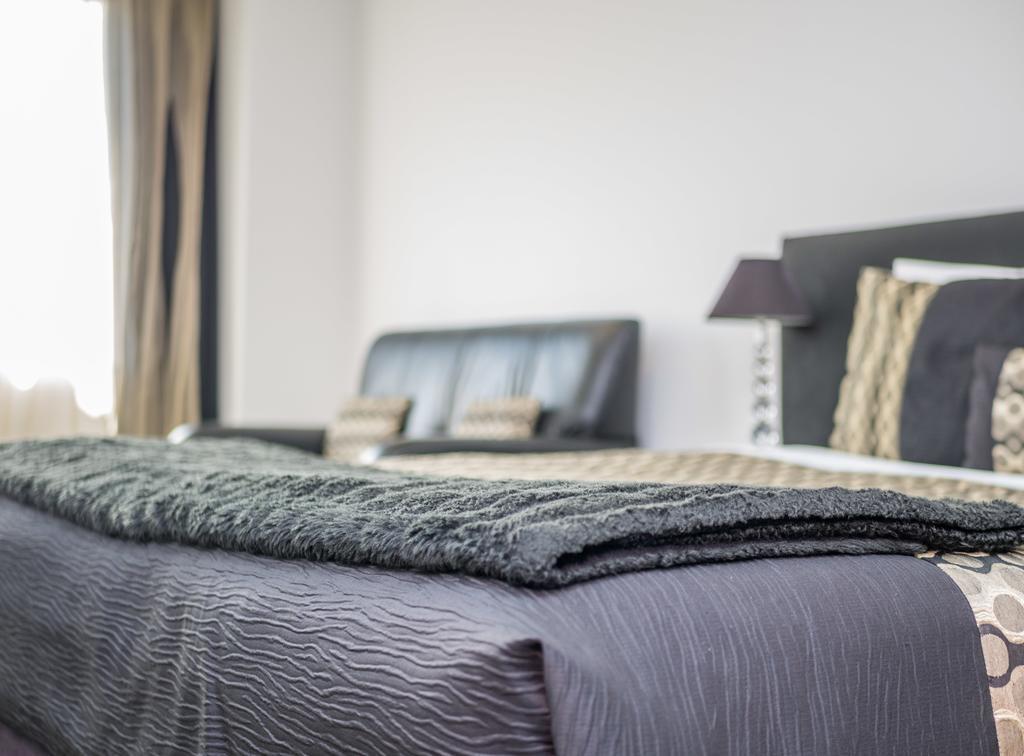Bellano Motel Suites Christchurch Eksteriør bilde A bed with a throw